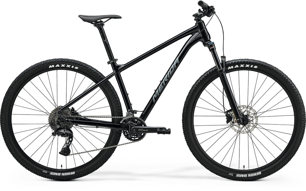 Side view of a black Merida BIG.NINE 300 hardtail mountain bike with front suspension, black frame, and Maxxis tires.