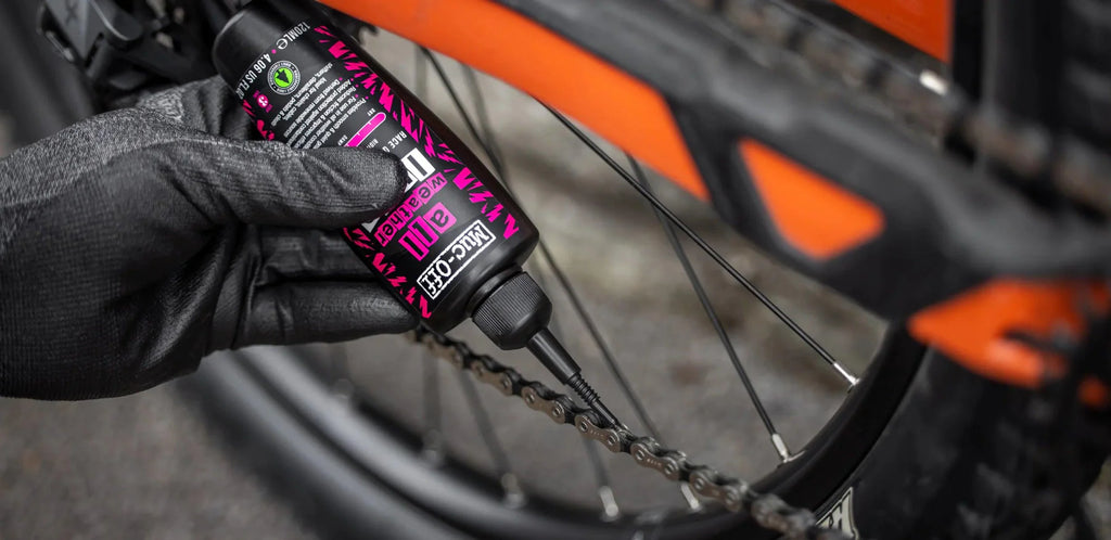 Lubricate bicycle chain with Muc-Off All-Weather Lube