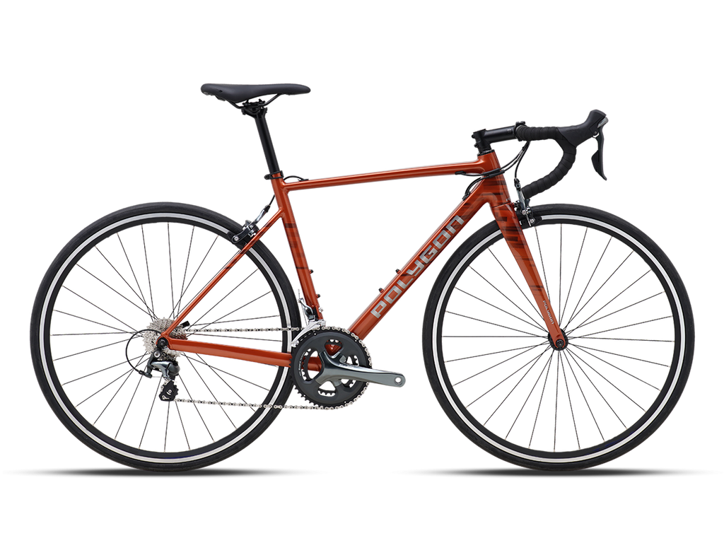 Full-side view of a burnt orange Polygon Strattos S4 road bike with black handlebars and seat, against a plain light background.