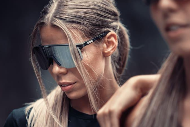 A woman wearing Bliz Hero Black Sport Sportglasses, dressed in a black top and sunglasses