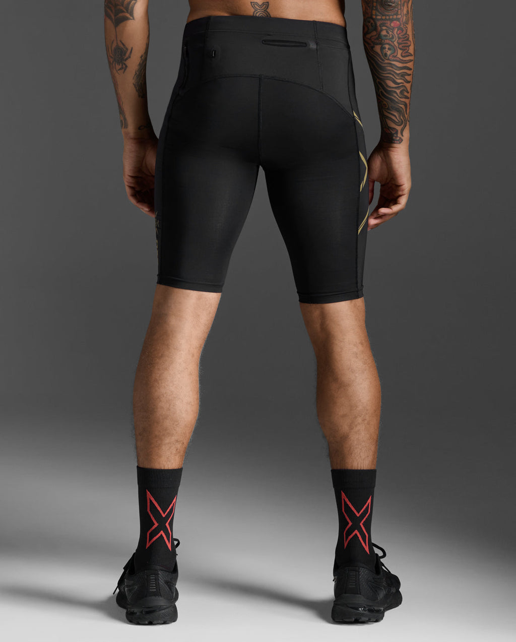 Rear view of the 2XU Light Speed Compression Shorts in Black/Gold Reflective showing the waistband zip pocket.