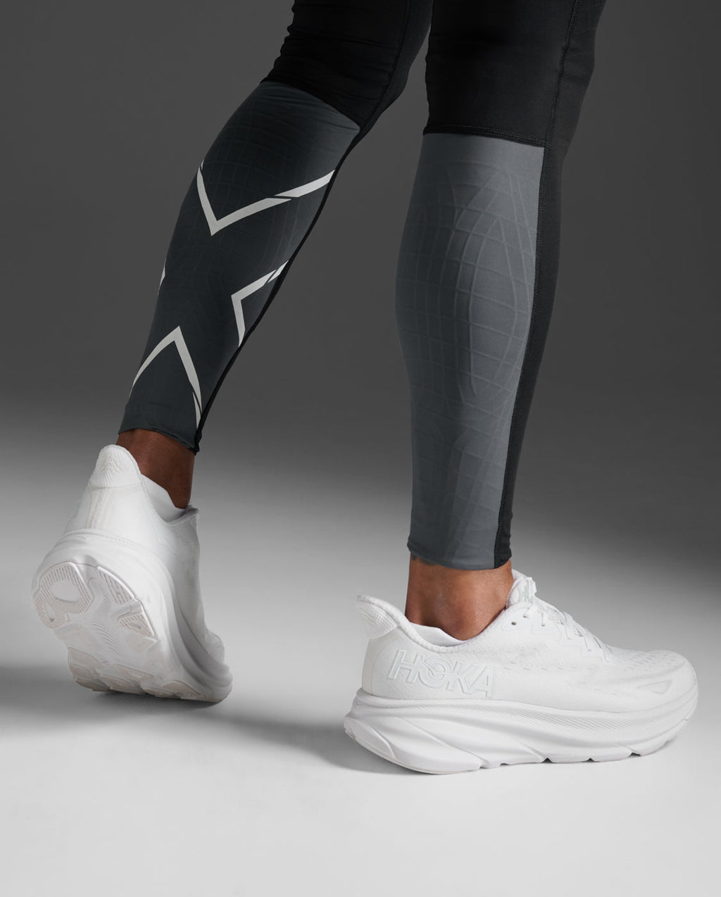 Close-up of the reflective X logo on the calf of the 2XU Light Speed React Compression Tights.