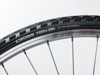 A close-up of a bicycle tire displaying the text "cross 700x32" on its sidewall.
