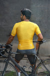 Cyclist man showing the back side of yellow cycling jersey