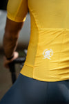 Cyclist man wearing yellow Aurelius cycling jersey showing back pocket