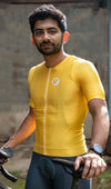 A man standing wearing yellow Aurelius cycling jersey