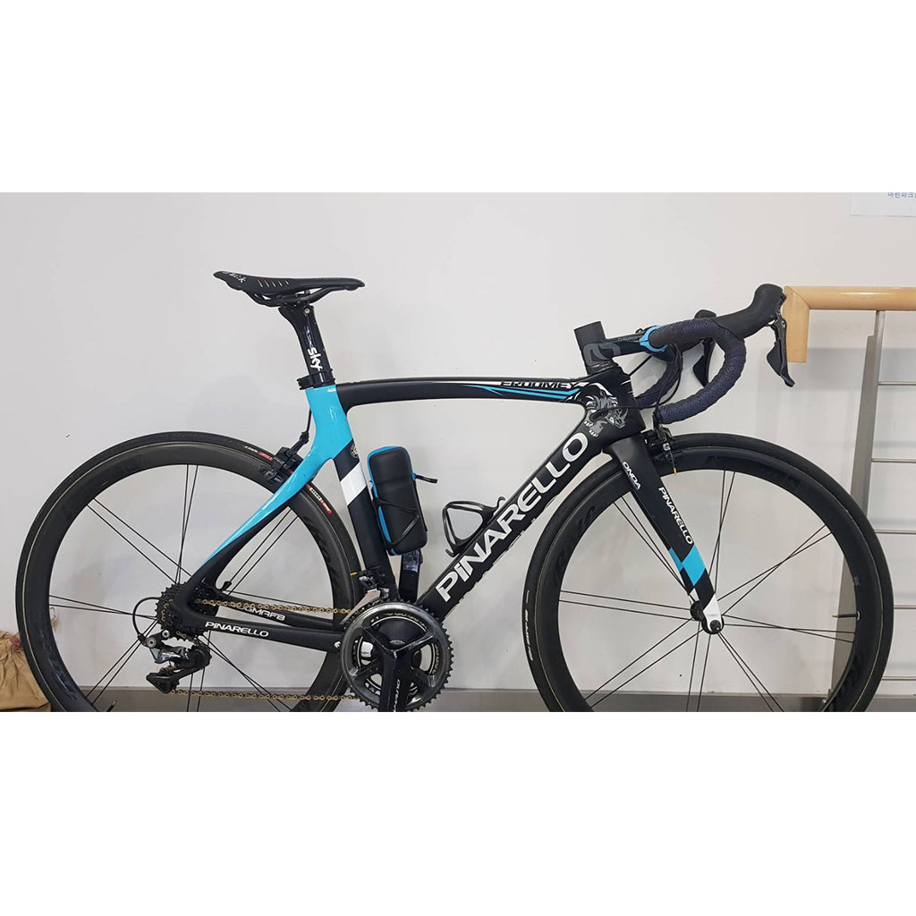 A bike featuring a blue and black frame, equipped with BTP reflective bartape in black with a square pattern