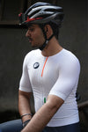 A man wearing white cycling jersey and a helmet