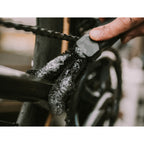 A close-up of the Dynamic Two Prong Brush being used to clean the rear triangle of a bicycle frame.

