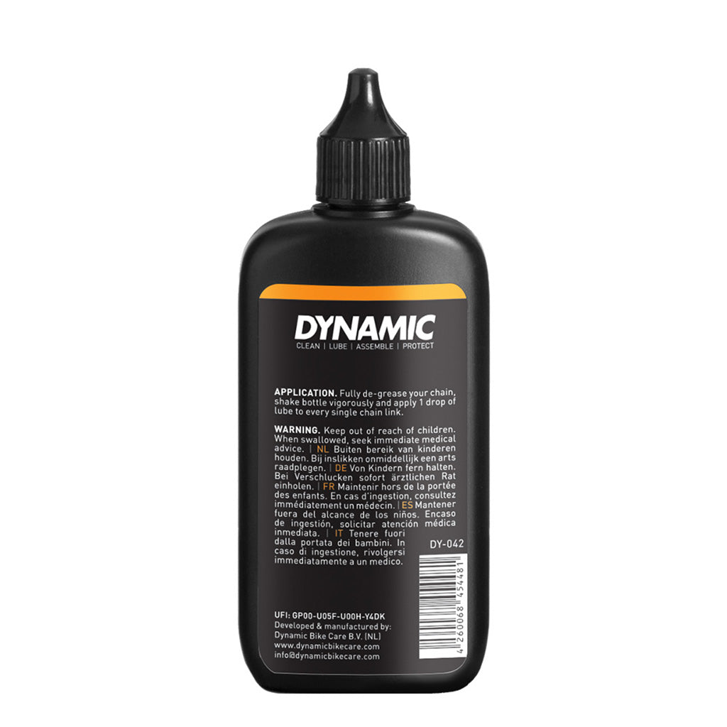 Dynamic Wet Lube is being applied to a bike chain to reduce friction and prevent rust during rainy rides.

