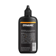 Dynamic Wet Lube is being applied to a bike chain to reduce friction and prevent rust during rainy rides.

