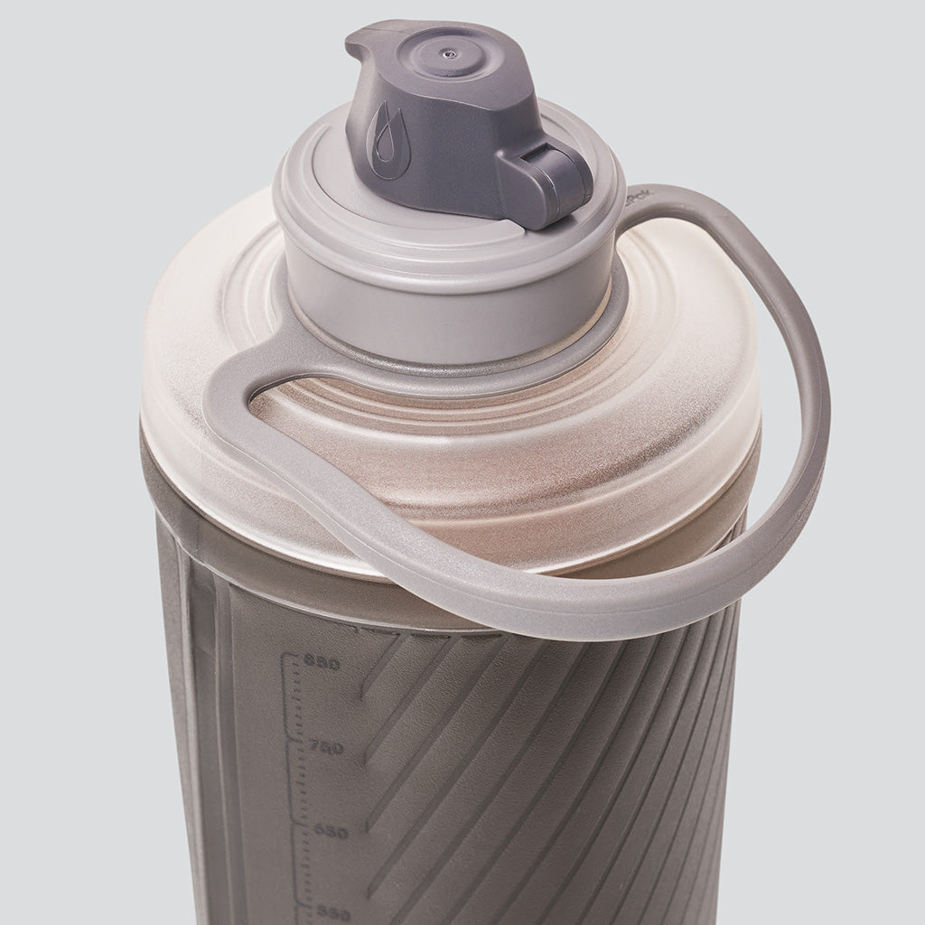 Hydrapak Flux 750ml Mammoth Grey bottle resting on rocky terrain during a mountain hike.

