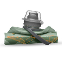 The 350ml Sutro Green Hydrapak Stow Flexible Bottle, Mountain Edition, demonstrating its ability to roll or fold for easy storage.