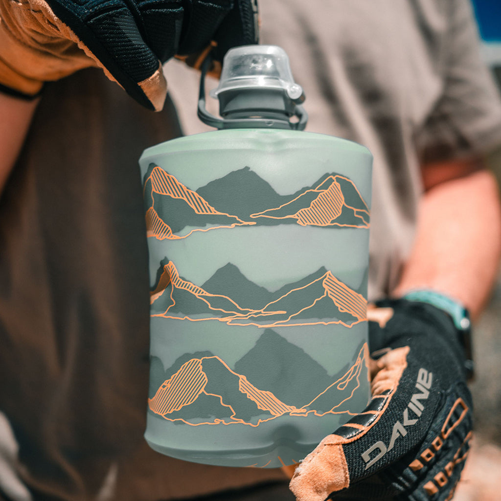 Close-up of the Hydrapak Stow Flexible Bottle, Mountain Edition, showing the cap and the flexible material in Sutro Green.