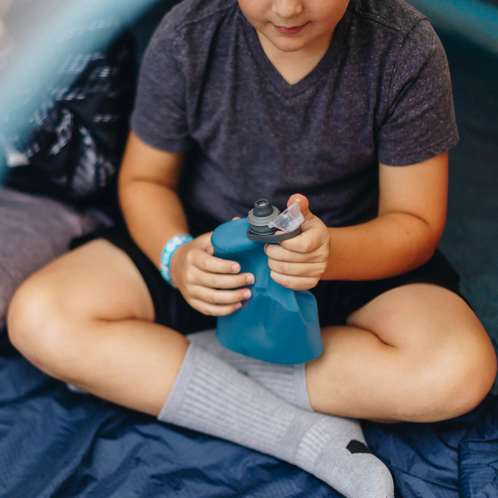 Illustrating the easy-to-use flip-top cap of the Tahoe Blue Hydrapak Stow 1L for quick hydration on the go.