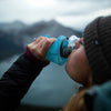 Refilling the Tahoe Blue Hydrapak Stow 500ml through its wide mouth opening for easy use.