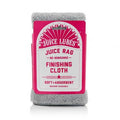 A folded yellow Juice Lubes Juice Rag microfiber finishing cloth with the brand logo clearly visible on a clean surface.

