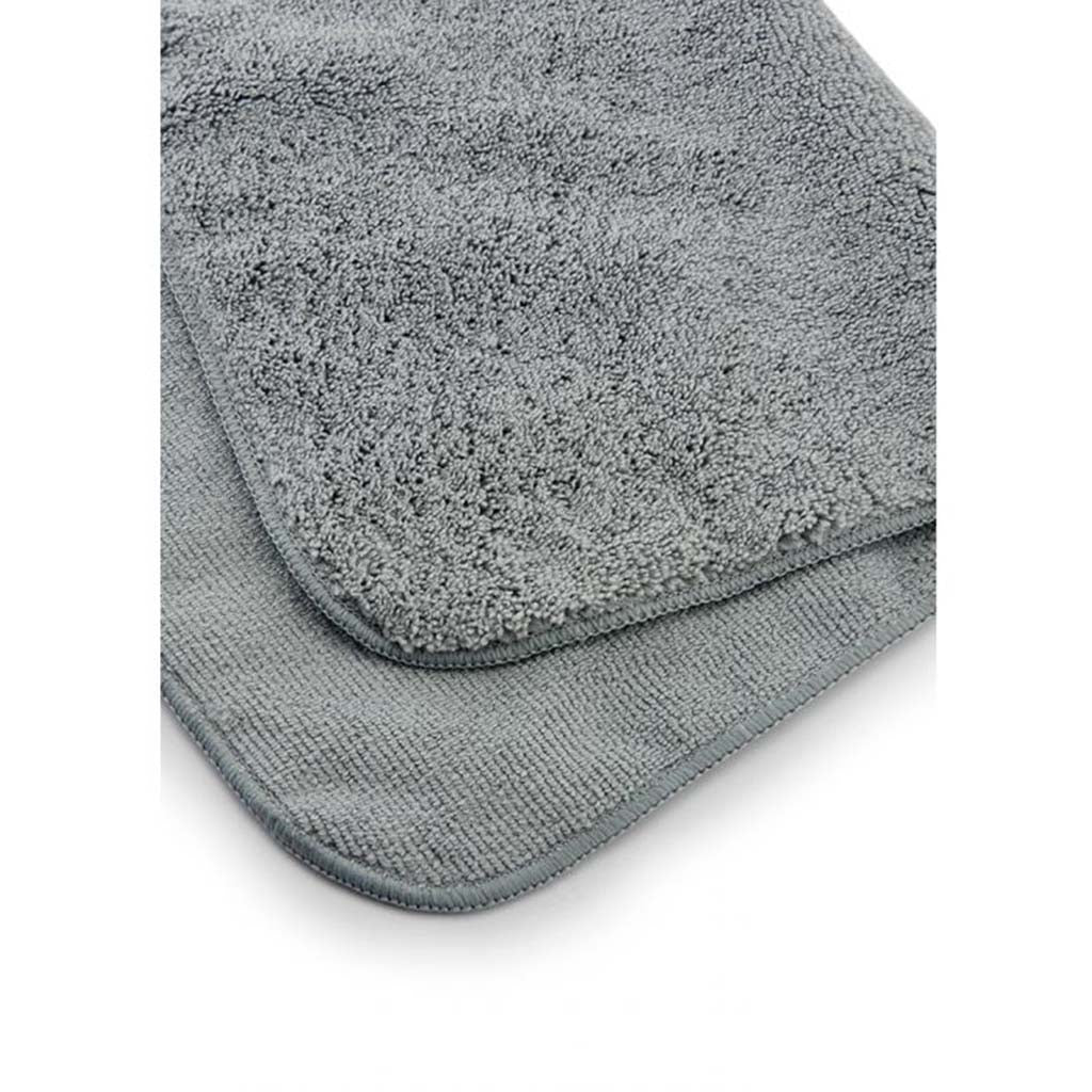 A hand holding the Juice Rag, shown in the process of wiping down and polishing a clean, shiny bicycle frame.