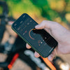 A hand holds a smartphone displaying the Magicshine App, used for customizing the EVO 1700 light.