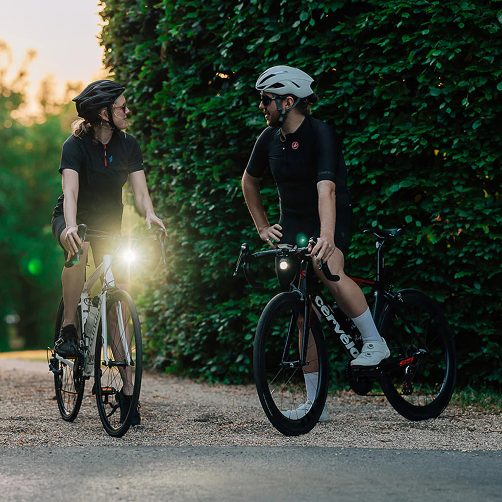 A person's hands are visible on bicycle handlebars, with the Magicshine EVO 1700SD bike light mounted below.