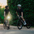 A person's hands are visible on bicycle handlebars, with the Magicshine EVO 1700SD bike light mounted below.