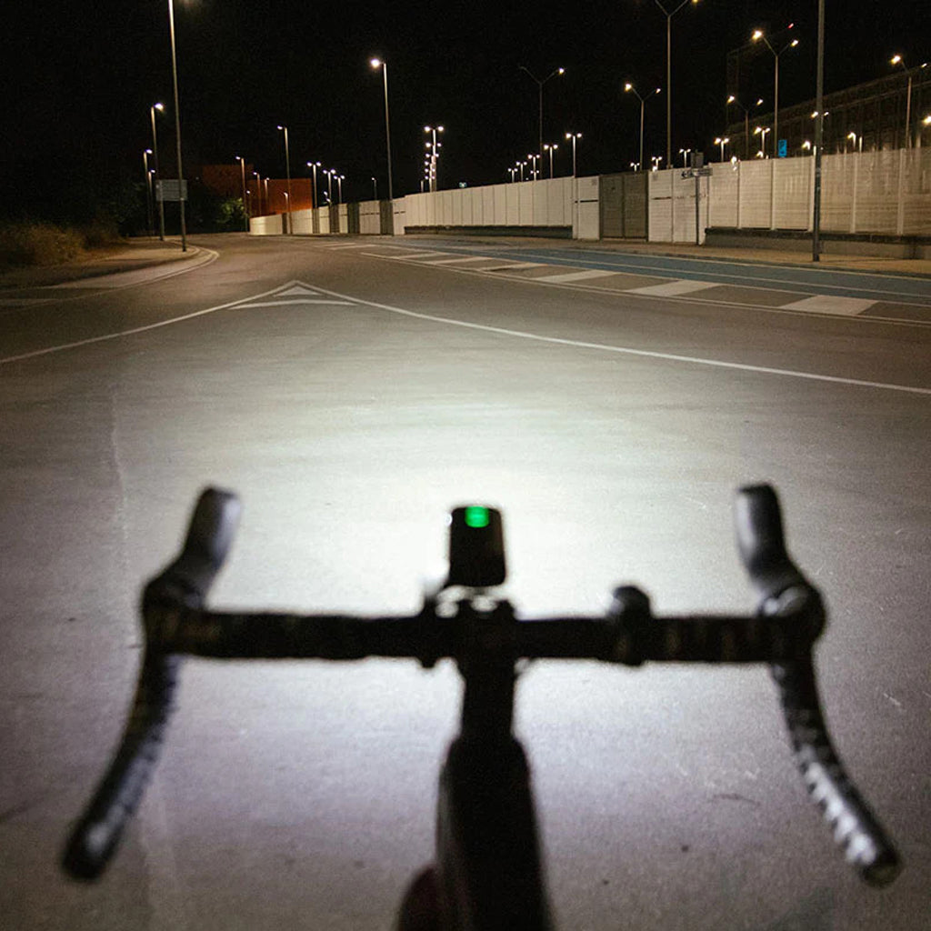 Cyclist riding at night with Magicshine front light illuminating the path.