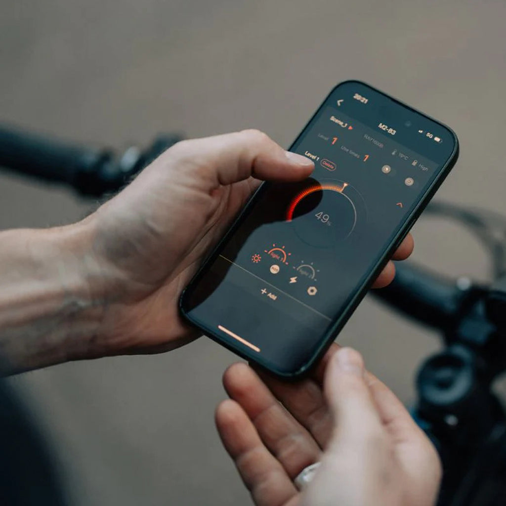 Smartphone showing Magicshine app for brightness and mode control.
