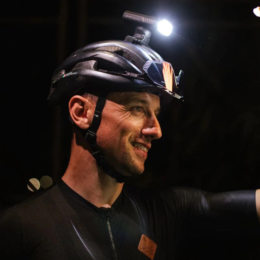 Cyclist riding at night with Magicshine front light illuminating the path.

