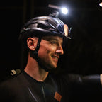 Cyclist riding at night with Magicshine front light illuminating the path.

