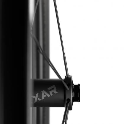 A close-up image of a bicycle wheel, highlighting the spokes, tire, and rim. The center hub is visible, showcasing the intricate details of the wheel's design.