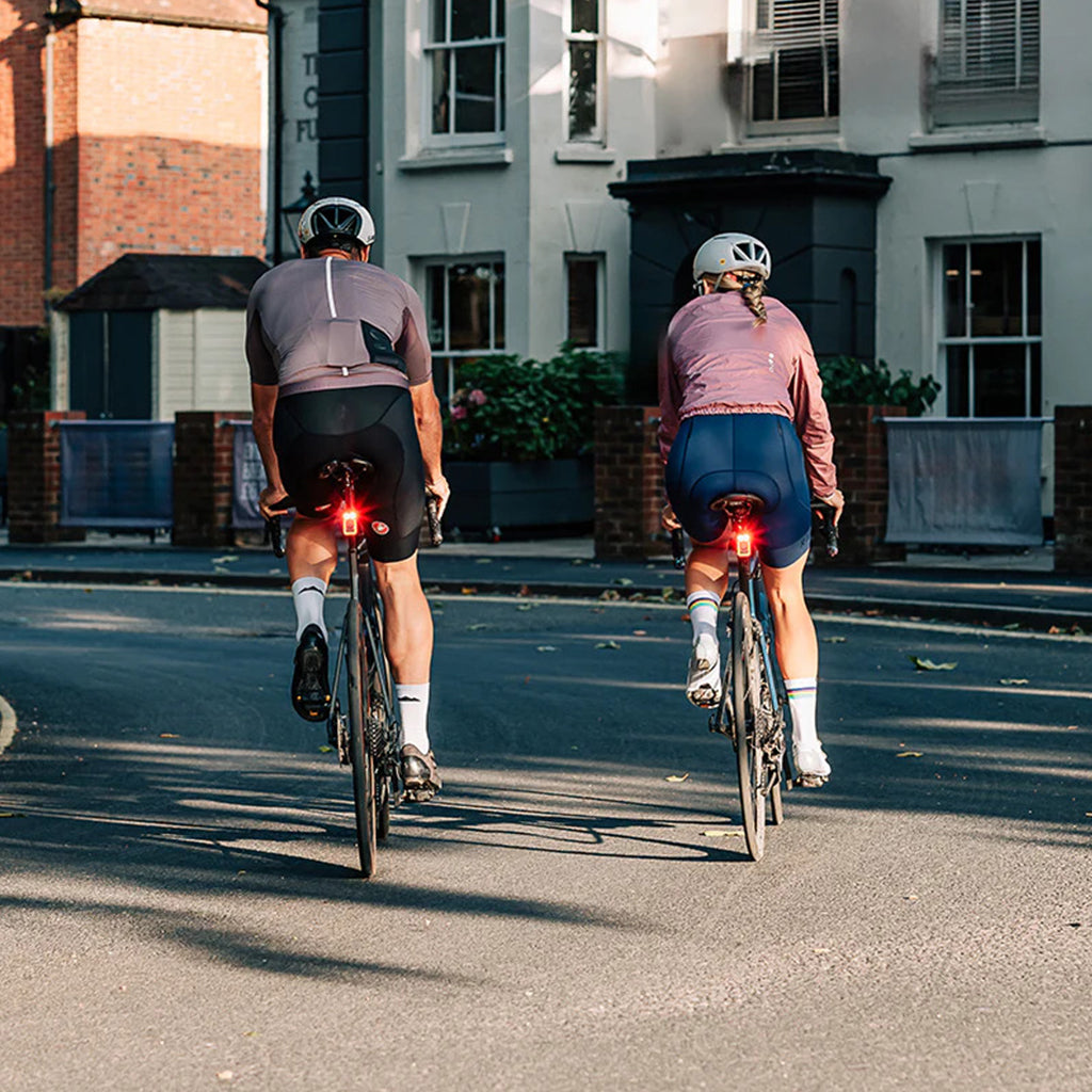 View from behind a cyclist using the Magicshine SEEMEE 100AD tail light, showing its powerful 100-lumen flash ensuring presence and reducing collision risks.