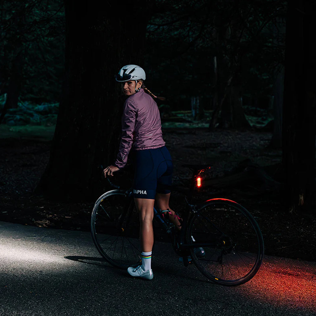 Cyclist riding a bicycle in an urban environment with the Magicshine SEEMEE 100AD Radar Rear Light (Black) actively detecting approaching vehicles for enhanced safety.