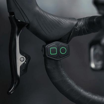 Magicshine Wireless Remote for EVO/RAY Series Lights mounted on a bicycle handlebar, with glowing green buttons, providing easy control of bike lights.