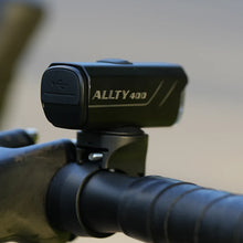 Magicshine ALLTY 400 V2.0 bike light mounted on a bicycle handlebar, viewed from the side, showcasing its USB charging port on the rear, against a blurred outdoor background