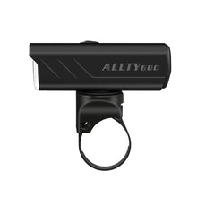 A black Magicshine ALLTY 600V2.0 bike light, shown at an angle, mounted on a handlebar strap, emphasizing its compact design and easy attachment.