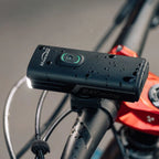 The Magicshine RAY 2600B front light is mounted on bicycle handlebars, seen from a rider's perspective.