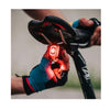 Hands wearing cycling gloves holding the Magicshine SEEMEE 200 V3.0 smart rear light near a bicycle seat, showing its compact size and how it attaches for secure mounting on a bike.