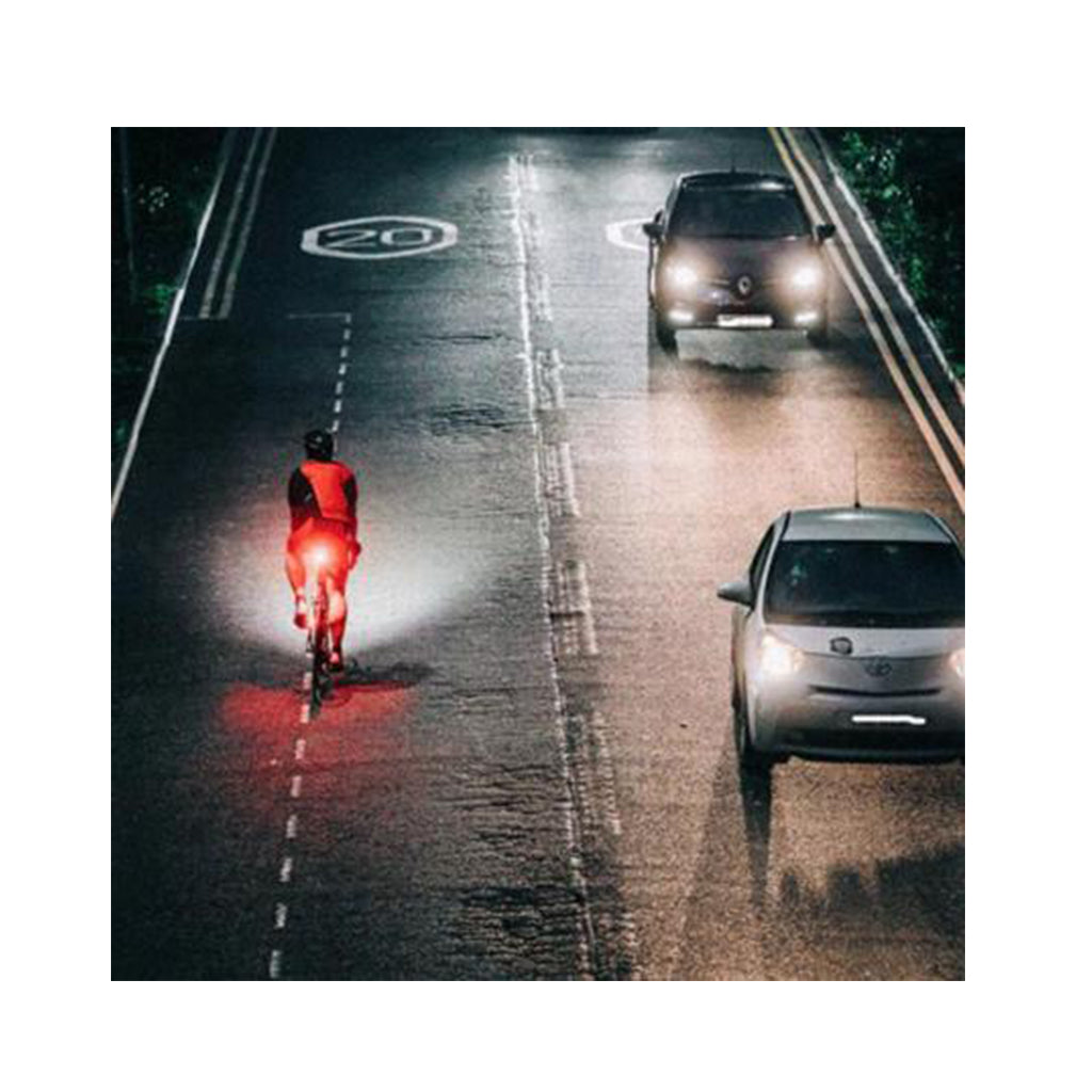 Cyclist on a road at night, illuminated by the Magicshine SEEMEE 200 V3.0 smart rear light