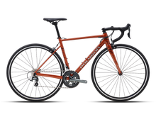 Full-side view of a burnt orange Polygon Strattos S4 road bike with black handlebars and seat, against a plain light background.