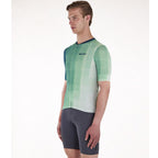 Cyclist wearing the Santini Paws Teal jersey, showcasing its slim fit and reflective details for high visibility.