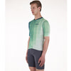 Cyclist wearing the Santini Paws Teal jersey, showcasing its slim fit and reflective details for high visibility.