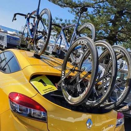A yellow car showcasing three bikes on its roof, all fastened with a TREEFROG L3 front wheel holder.