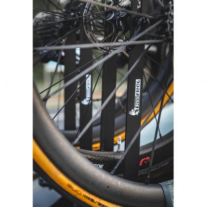 Close-up of a bicycle's front wheel, showcasing the TREEFROG L3 front wheel holder in action