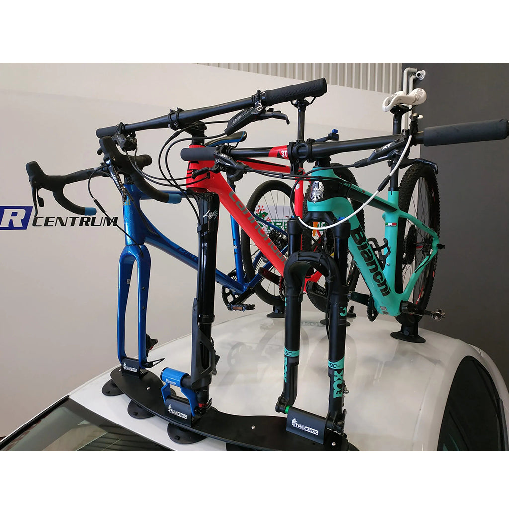 Car roof equipped with a bicycle rack holding a bike, showcasing the TreeFrog 9QR-15X100mm Thru Axle Fork Mount Bracket.
