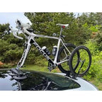 A car with a bicycle mounted on its roof, held in place by a TreeFrog L1 Front Wheel Holder, perfect for cycling trips