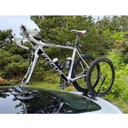 A car with a bicycle mounted on its roof, held in place by a TreeFrog L1 Front Wheel Holder, perfect for cycling trips