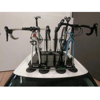  A car with a TreeFrog L2 bike rack on top, holding two bikes securely in place. Perfect for outdoor adventures