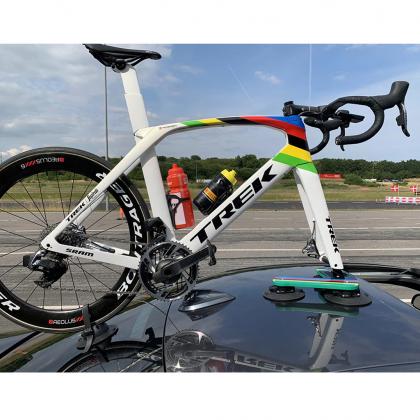 A bike on a car's roof rack with a vibrant rainbow in the background, showcasing the TreeFrog Pro 1 Bike Rack
