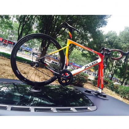 A bicycle rests on a car, showcasing the TreeFrog Pro 1 bike rack designed for road and mountain bikes