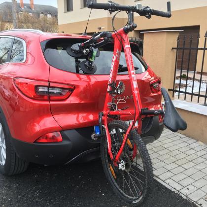 A red car equipped with a TreeFrog Pro 1 bike rack, showcasing a bike attached to the back for outdoor fun